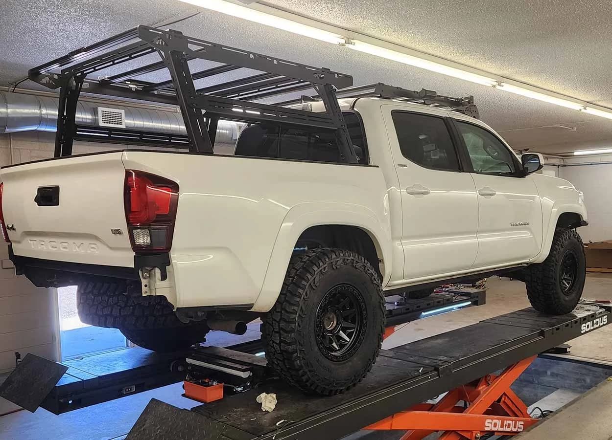 pickup truck raised on an alignment rack in a collision repair shop